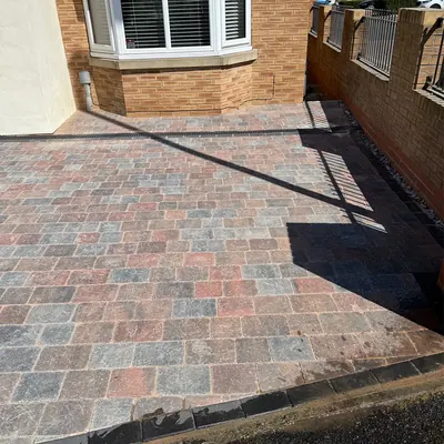 Brindle block paved drive by Hillcrest next to a low brick wall